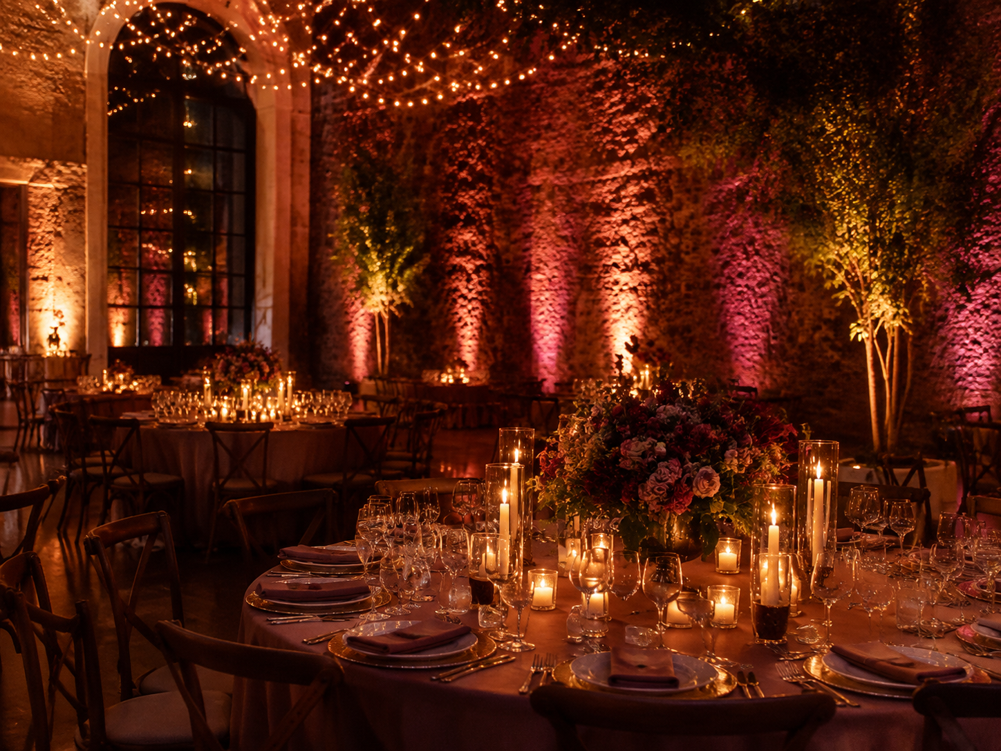 Candlelit event venue with warm uplighting and fairy lights