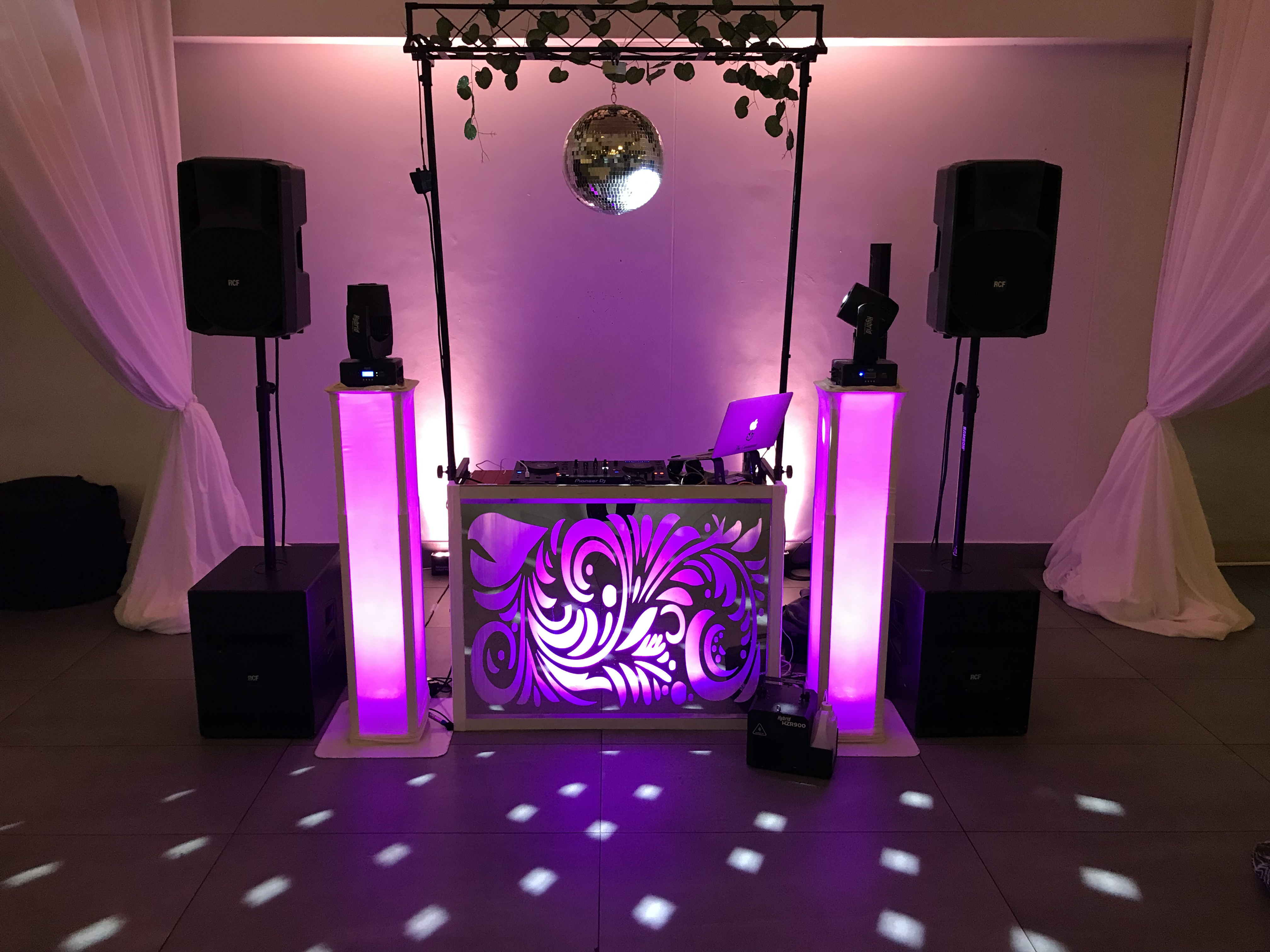 DJ booth with purple lighting and disco ball